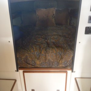 Storage below bunk w/ cabinet built to match the rest of the boat.