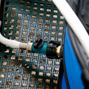 An ordinary garden hose coupling and cutoff valve is plumbed into the collapsible tub drain. The hose empties into the mid ships bilge and 1100 gph bilge pump empties the water overboard.