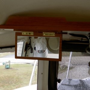 Valkyrie: Fold-down vanity mirror is glued to teak. Brass hinges and screws are used.  In response to a few PM's: the mirror wasn't centered on the aisle because that space is reserved for future projects.  The mirror is only sightly above the other seat, but can easily be used when standing in the aisle.