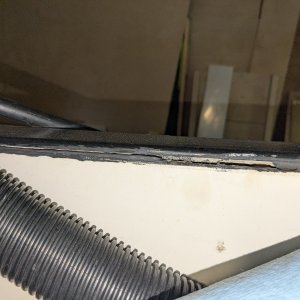 Fibreglass skins separated beneath black plastic transom cap, exposing core.