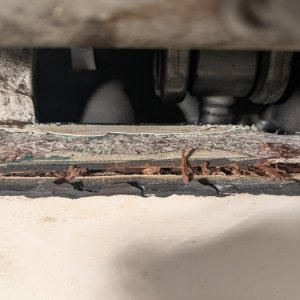 Close-up of rotten wood picked out from gap in transom fibreglass.