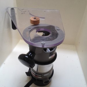 We\'ll use a router with a spiral upcut bit to make the hole. Luckily I have a multi-purpose router base and with a wooden plug to fit the existing hole, it will guide the circle cut.