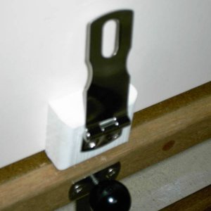 Stainless hasp with TyBoo gizmo below with the locking knob in place. Knobis counter sunk into edge of new floor and hasp is on seat face.