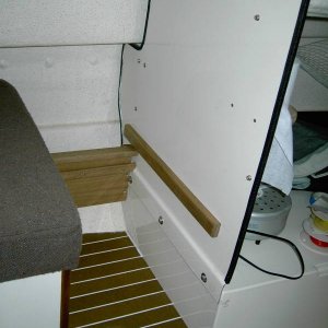 Seat moved aft. Wooden bumper installed on bulkhead keeps seat box from rubbing on bolt heads below. Bin front end is in center of photo.