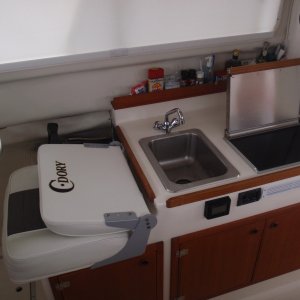 Galley - sink, Wallas diesel cooktop/heater w/small black control, Stbd interior window shade, Vessel Sys DC Monitor VSM 422 in front of sink