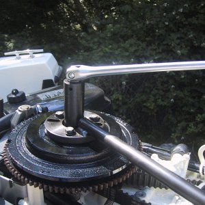 Using special  OMC tools, remove flywheel bolt.