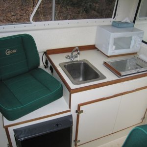 (Sea Skipper) Galley unit ? Wallas stove located toward front of cabinet leaves space for microwave behind.  Microwave raised 1" so door can be opened over stove top.