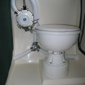 (Sea Skipper) Lavac vacuum head with manual waste discharge pump.  2nd Y valve (hidden behind head) is used to route suction line to a bilge strainer mounted below cabin steps for use as an emergency bilge pump.  Head is mounted at a comfortable height on an 8? PVC pipe cap.