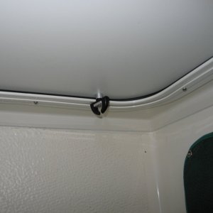 Single (window) turn catch located at base of shower door opposite the hinge side will hold lower part of door tight against the sealing gasket eliminating "all" leaks.  Several 1/8" drain holes were drilled in the aluminum door frame just above the lower gasket to duct the small amount of water that collects between door and frame back to shower stall.  The catch was slightly modified to permit opening by screw driver from the outside if necessary and for correct spacing.