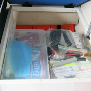 Forward seat storage with slidable tray.