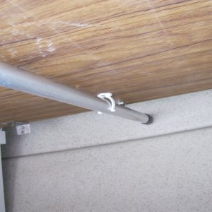 View of table in stored position from underneath: I pitched the 1" square rusty table leg last season with a 1" tubular aluminium one and now leave it attached. It is held up with a Beckson clip. Bliss. When I list the table into position, I flip the leg down.