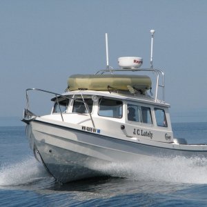 JC Lately crossing our wake, Whidbey Island in the background, on a glass flat day on Juan de Fuca.