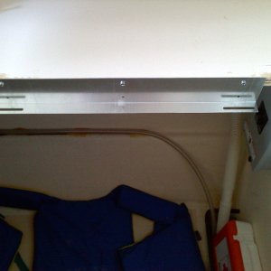04/01/2010, bracket for cooktop, mounted flush with counter top, one each side, circuit breaker box mounted inside cabinet, visible to just right of bracket.