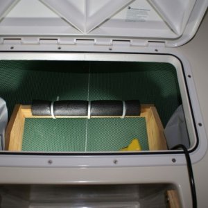V-Berth Storage Install -DSC06190 Closed cell foam and a little wood divider to keep things in place.  The gray bags on either side hold spare props.