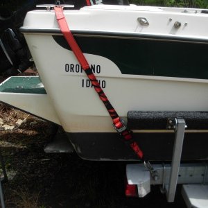 The boat came with two straps that went from the same eye hook on the trailer frame to eye bolts on the bak of the boat at the same elevation as my home port Orofino.  It did not seem to me they would do much to hold the boat on the trailer in a big highway bump, so I went to the clete as shown.  I considered a strap that would wrap across the whole cockpit from one side to the other with just one large winch. I rejected that because using the boat for camping (boater-homing") you would need to remove it to get in the boat.