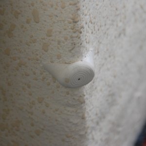 Galley cabinet door bumper made from a pole leg stopper, cut to fit and mounted with 5200