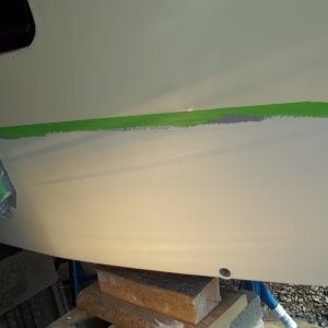 4/25/2011..transom view/marine tex filled screw holes hard as rock after sitting (24 hrs)with heat lamp,sanded and applied two coats of ( White )epoxy/wavy lines you see are reflections thru the plastic shelter walls