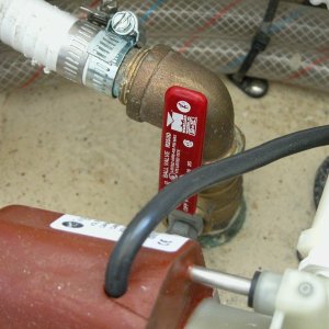 Sea Angel head seacock with its red handle in the open position. The two 'clear water lines at the top of the pix are the hot and cold lines to the shower and sink. The brown device at the bottom of the pix is the air conditioner's raw water pump motor frame.