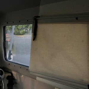 Shade is split to allow air circulation from forward side windows. Shade is made from canvas with dowel rods on top and bottom to allow easy rollup.