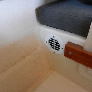 The two vents allow heat to escape, there is sufficient bilge venting down low for cool replacement air.  This vent in under the dinette table.