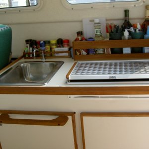 Galley: teak racks and towel bar.  Note forward position of stove.  We specified this when ordering so we would have space behind for storage.  It seems that most stoves are mounted too far back.
