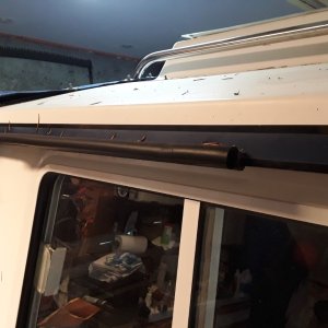 Widow "gutter" made from press-on gasket material used for sealing hatches.  It is available in 180 and 90 degree (this is 90 degree used to form a gutter to keep rain from dripping in the captain's window.  I used the 180 degree for "head protection" above the cabin entrance.