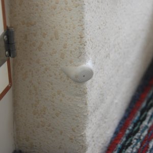 Bumper set with "5200" to protect cabinet door. 
As a side note: A fitted grey indoor/outdoor carpet is laid over fitted 'dry deck' panels and a colored(viewed) runner is placed on top. Each is very easy to remove,clean or replace.