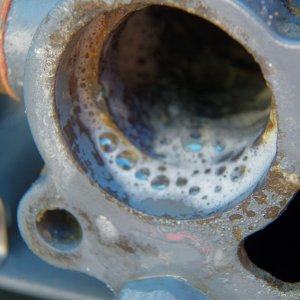 I switched to industrial vinegar (10%) and later to muriatic acid.  That cleaned things up in a hurry.  I actually soaked the old thermostat clean and kept it for a backup.  A car thermostat, which doesn't get any build up, is good for decades.  Why not an outboard thermostat with the build up dissolved periodically?