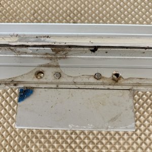 I think the reason it never sealed correctly (I'm guessing from the factory ) is that the machine screws that hold the hinges stick out about 1/32 -1/16.
When the hatch was tightened down the screws left a mark on the gel coat and stopped the hatch from fully compressing the caulk right underneath the hinges.