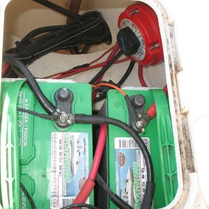 This photo shows the boat's original batteries (two Group 24 flooded cell batteries) and switch (1-2-Both-All). Many leads going right to battery terminals, no buses, just not very tidy.  Battery trays were screwed right into core, original (leaky) hatch lids, etc.