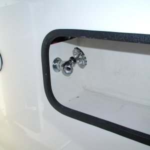 Faucet for raw water wash down installed in Port cockpit wall compartment.