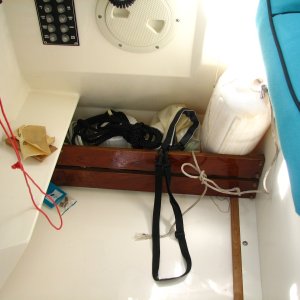 Corral for spotlights, fender, ditch bag on the floor outboard of helm seat