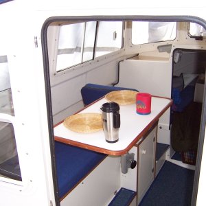 C-Swell did not have a table so I decided to add a Garelick stowable table. I added cherry wood molding made by my Dad to keep things from sliding off and to go with the other wood trim in the cabin.