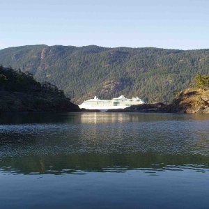 Alaska Cruise Ship headed norht viewed from our anchorage through a gap in the islands
