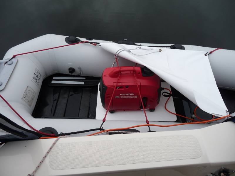 5. In rainy weather I put the 3-1/2" thick foam seating pad that I use normally in the dingy, under the 1/4" white plastic sheet the generator sits on to give it more distance off the bottom of the dingy. The white tarp bungy cord's on above the generator to protect it from the rain.