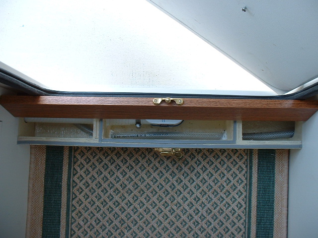 Center compartment is glassed to be watertight. The water supply line for the sink runs through and is siliconed to prevent leakage into the smaller storage compartments.