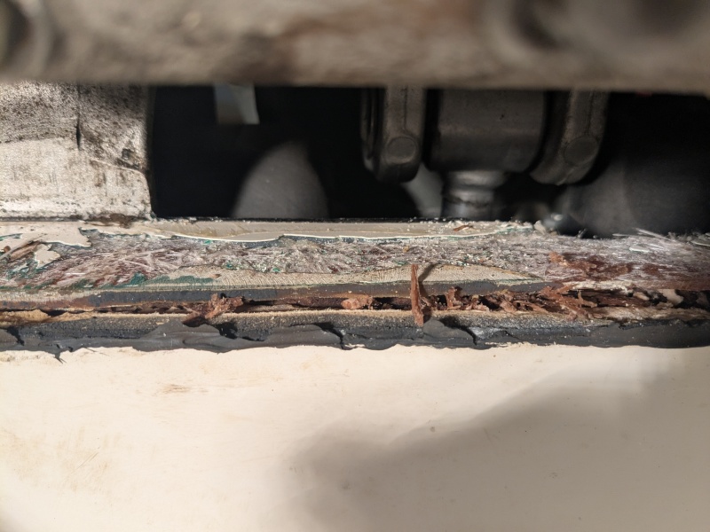 Close-up of rotten wood picked out from gap in transom fibreglass.