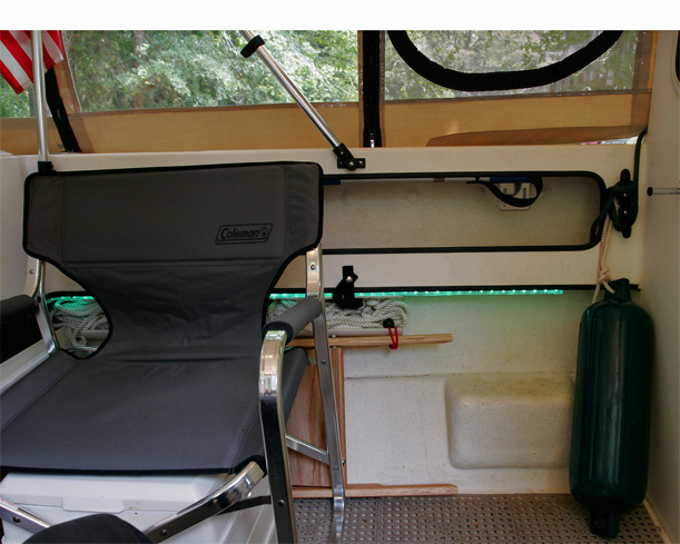 Coleman chairs are comfortable and have a handy pull up shelf. Chairs are stowed under gunnels when trailering.Also note the cleat added inside the cockpit at the end of the gunnel tray. This is used to tie off and adjust the middle fender and to tie off the forward and aft docking lines so that they are in hand as we step onto the dock.