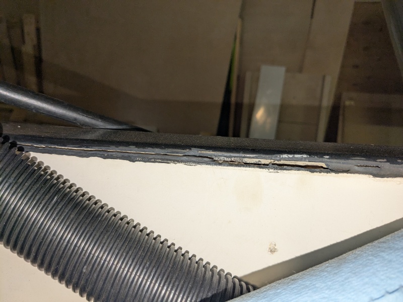 Fibreglass skins separated beneath black plastic transom cap, exposing core.