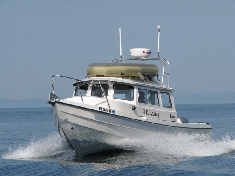 JC Lately crossing our wake, Whidbey Island in the background, on a glass flat day on Juan de Fuca.