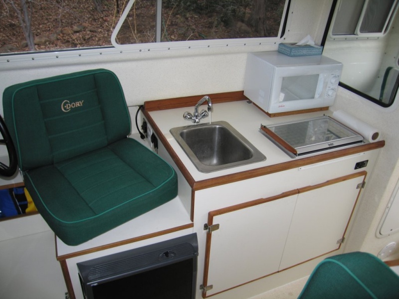 (Sea Skipper) Galley unit ? Wallas stove located toward front of cabinet leaves space for microwave behind.  Microwave raised 1" so door can be opened over stove top.
