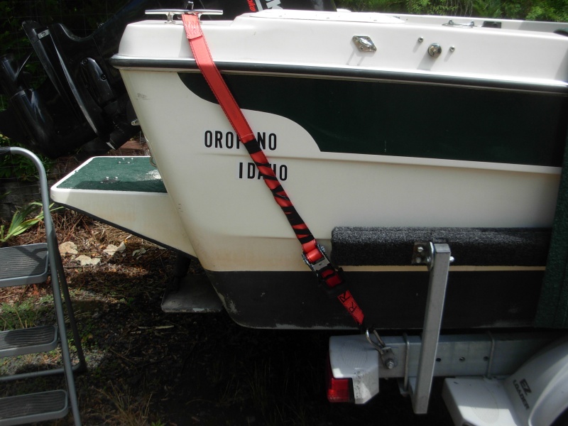 The boat came with two straps that went from the same eye hook on the trailer frame to eye bolts on the bak of the boat at the same elevation as my home port Orofino.  It did not seem to me they would do much to hold the boat on the trailer in a big highway bump, so I went to the clete as shown.  I considered a strap that would wrap across the whole cockpit from one side to the other with just one large winch. I rejected that because using the boat for camping (boater-homing") you would need to remove it to get in the boat.
