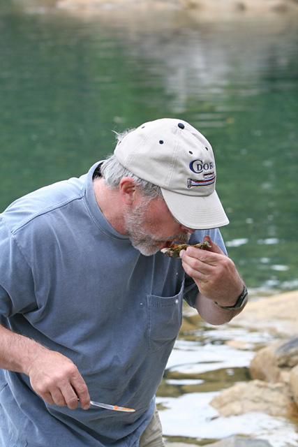 Tom enjoys a steamed oyster.