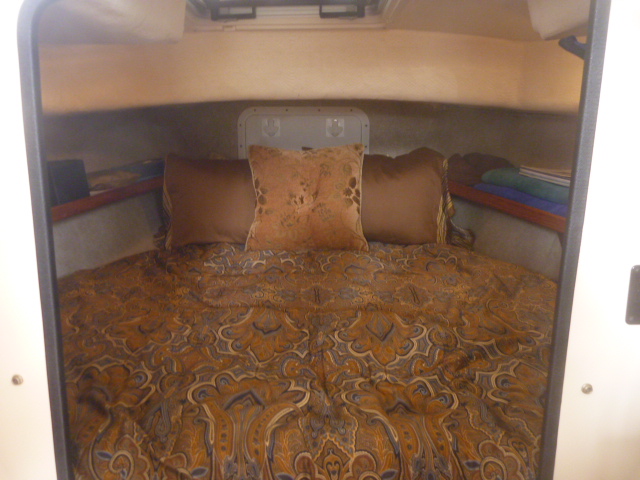 V-berth with custom memory foam matress & bedding, hypervent under matress, walls insulated with closed cell foam & lined with tan carpet/headliner.